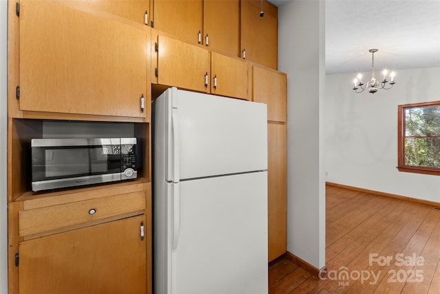 550 Kinross Dr, Flat Rock, NC 28731 - kitchen featuring a notable chandelier, white refrigerator, light hardwood / wood-style floors, and pendant lighting