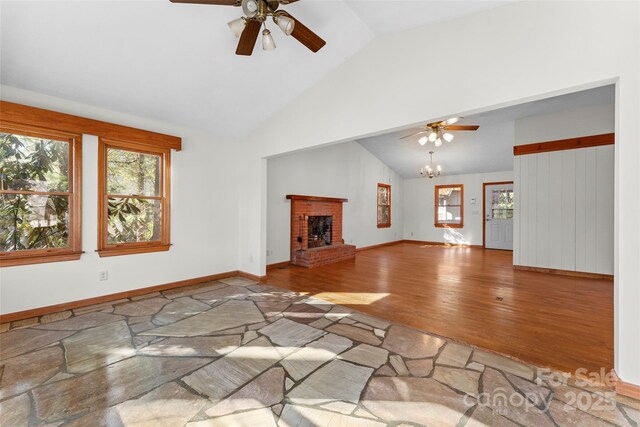 550 Kinross Dr, Flat Rock, NC 28731 - unfurnished living room featuring vaulted ceiling, ceiling fan with notable chandelier, a fireplace, and hardwood / wood-style floors