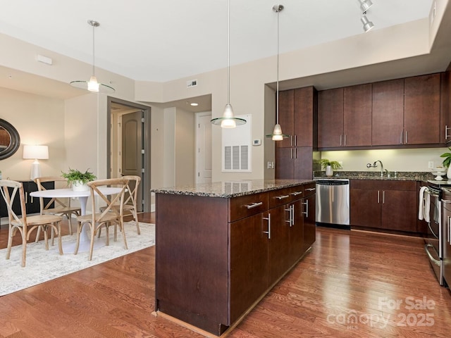 kitchen featuring stainless steel appliances, dark brown cabinets, and dark hardwood / wood-style flooring