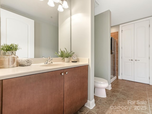 bathroom featuring vanity, toilet, and an enclosed shower