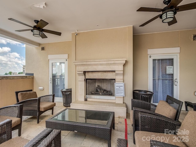 living room with a premium fireplace and ceiling fan