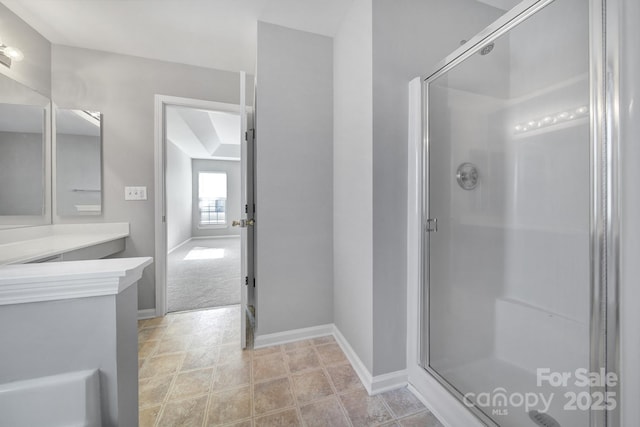 full bath featuring a stall shower, vanity, and baseboards