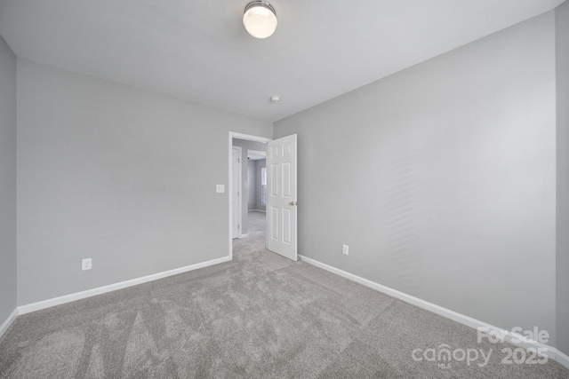 carpeted spare room featuring baseboards