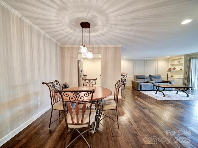 dining space with ornamental molding and dark hardwood / wood-style flooring