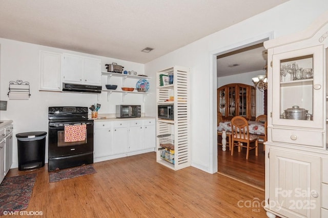 kitchen with white cabinetry, an inviting chandelier, light hardwood / wood-style floors, and black appliances