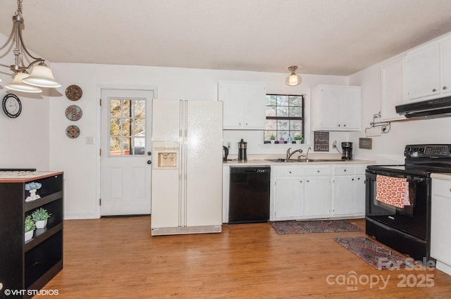 kitchen featuring hanging light fixtures, black appliances, and white cabinets