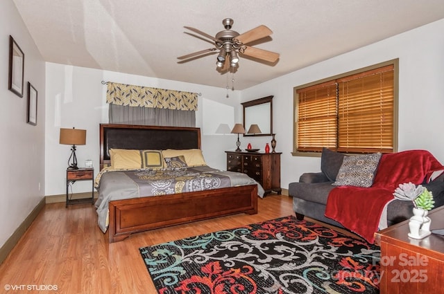 bedroom with hardwood / wood-style floors, a textured ceiling, and ceiling fan