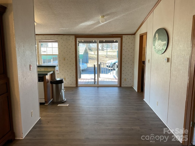 interior space featuring ornamental molding, a textured ceiling, and dark hardwood / wood-style flooring