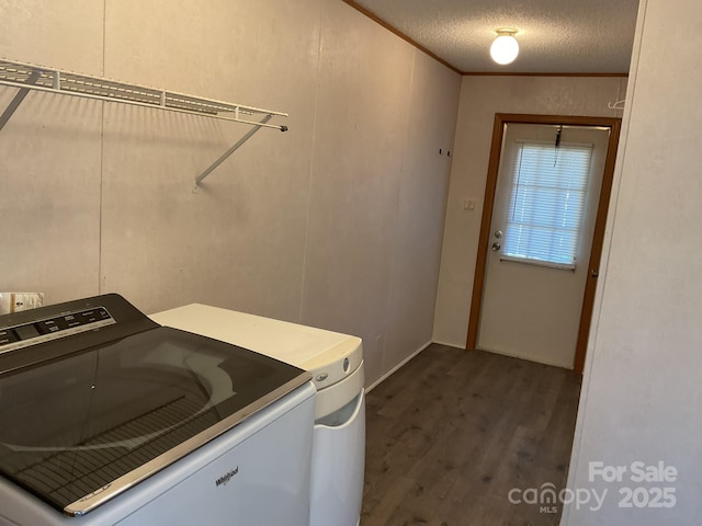 laundry room with dark hardwood / wood-style floors, ornamental molding, washer and dryer, and a textured ceiling