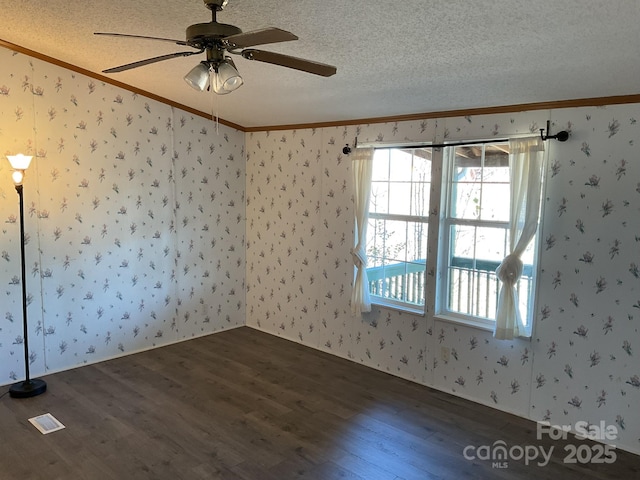 spare room with dark hardwood / wood-style flooring, ceiling fan, crown molding, and a textured ceiling