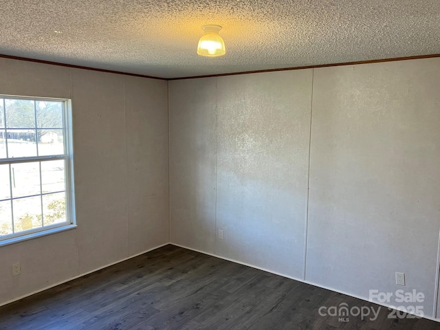 spare room featuring dark hardwood / wood-style floors and a textured ceiling