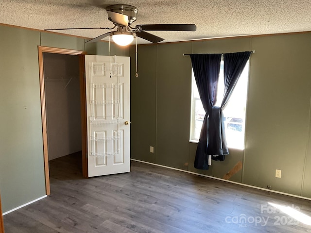 unfurnished bedroom with ceiling fan, wood-type flooring, a closet, and a textured ceiling