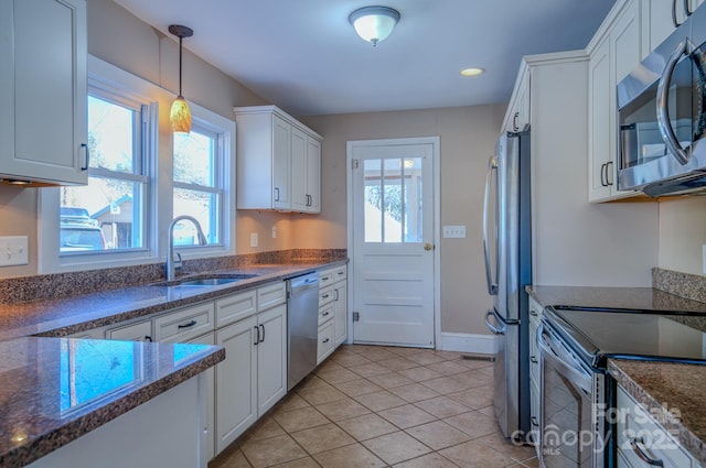 kitchen featuring sink, light tile patterned floors, hanging light fixtures, stainless steel appliances, and white cabinets