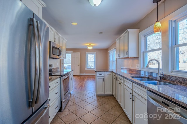 kitchen with white cabinets, kitchen peninsula, sink, and stainless steel appliances