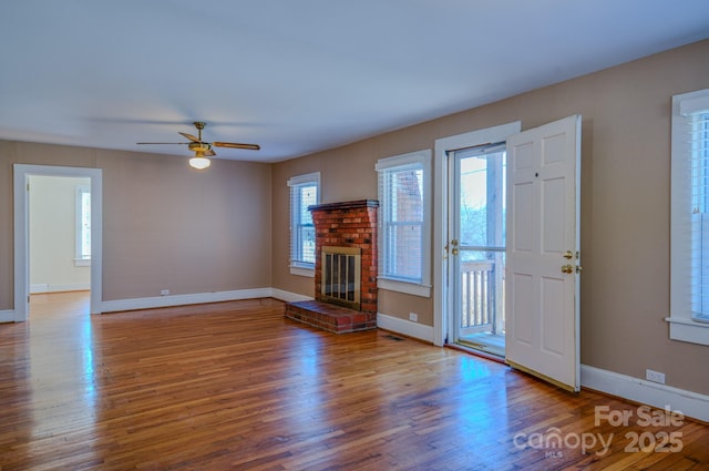 unfurnished living room with ceiling fan, hardwood / wood-style floors, and a fireplace