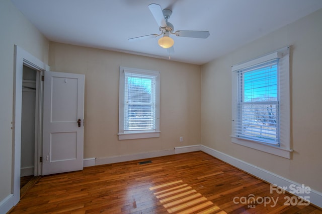 unfurnished bedroom with ceiling fan, hardwood / wood-style flooring, and a closet