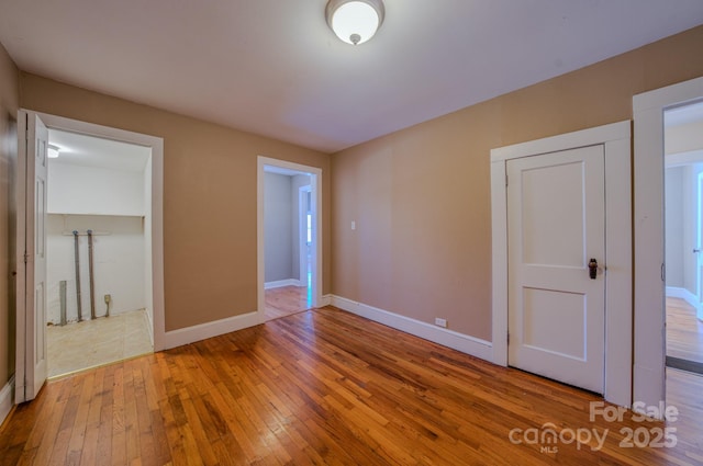 unfurnished bedroom with a closet and hardwood / wood-style floors