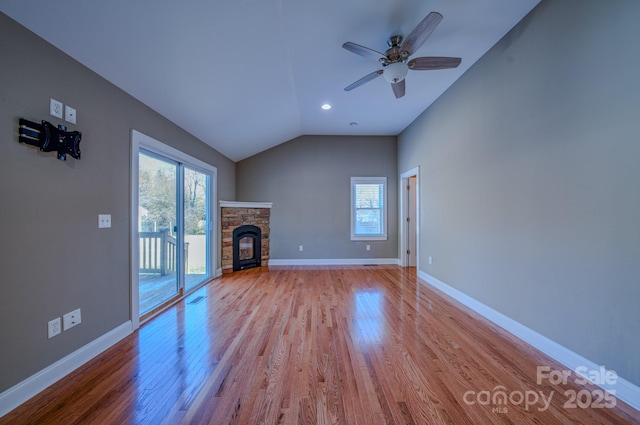 unfurnished living room featuring light wood-type flooring, ceiling fan, vaulted ceiling, and a fireplace