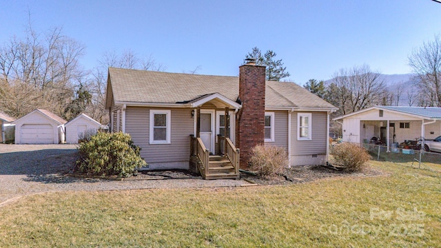 bungalow-style home with an outbuilding, a front lawn, and a garage