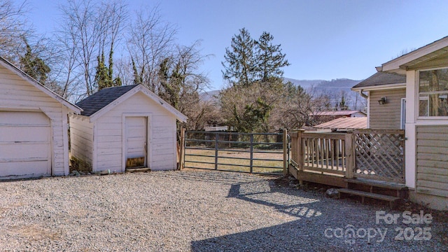 view of yard with a deck with mountain view and a storage shed