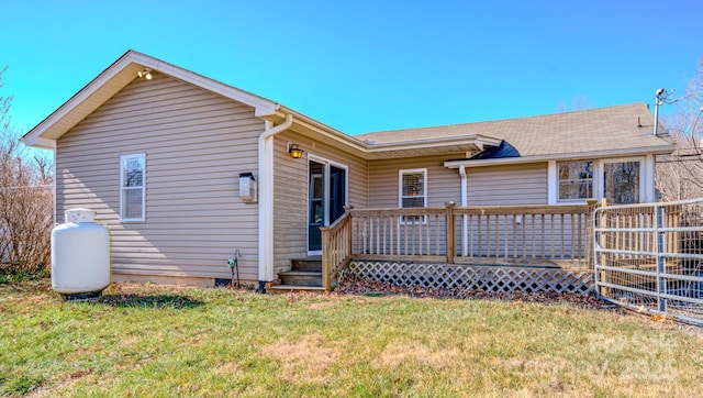 rear view of house with a wooden deck and a yard