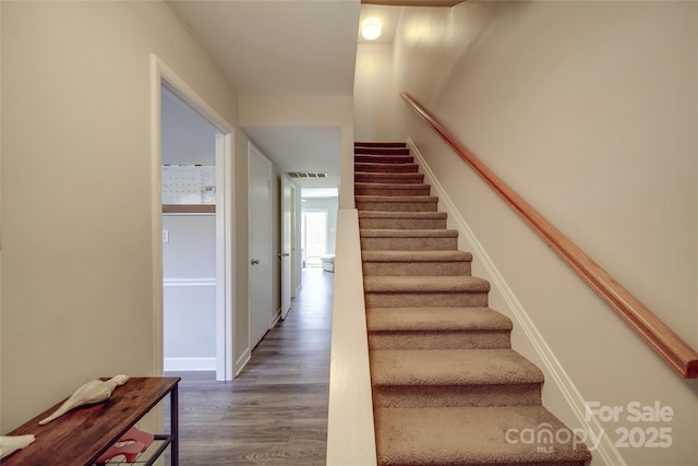 stairs featuring hardwood / wood-style flooring