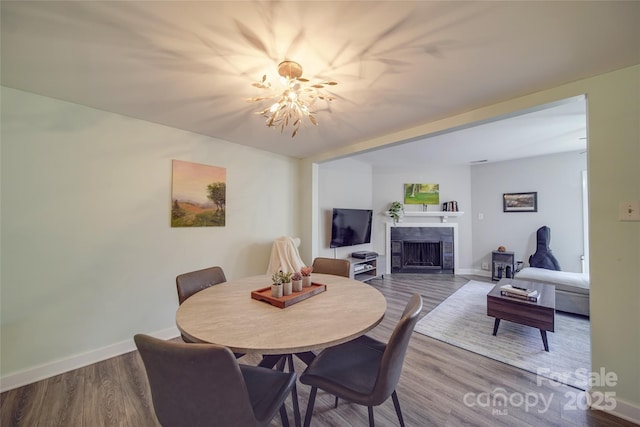 dining area with a tiled fireplace and hardwood / wood-style flooring