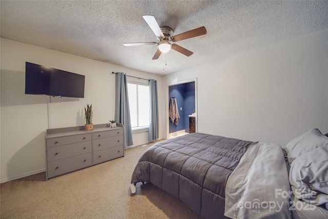 bedroom with ceiling fan, light colored carpet, and a textured ceiling