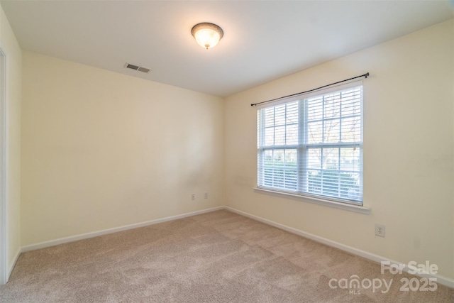 unfurnished room featuring light carpet