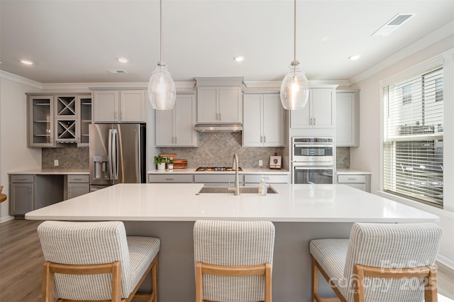 kitchen with stainless steel appliances, a breakfast bar area, and a large island with sink