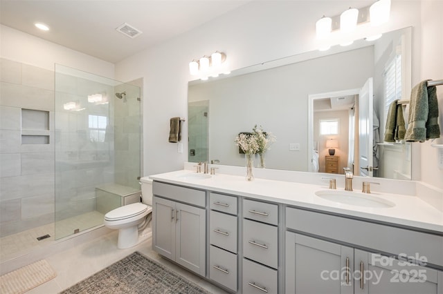 bathroom with tile patterned floors, vanity, toilet, and a shower with shower door