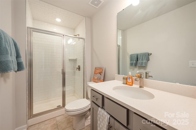 bathroom with vanity, tile patterned flooring, a shower with shower door, and toilet