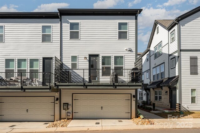 rear view of house featuring a garage and a balcony