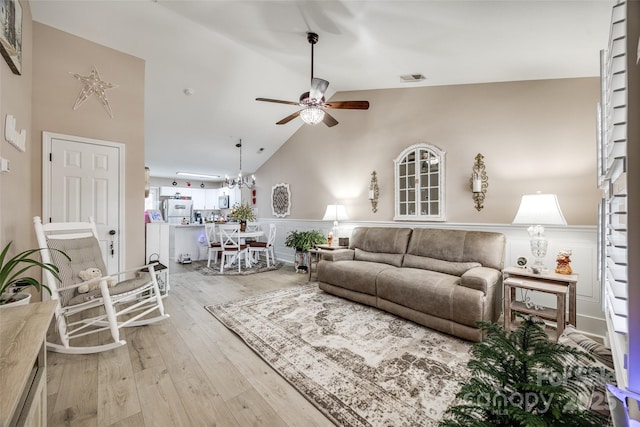 living room featuring wood-type flooring, high vaulted ceiling, and ceiling fan