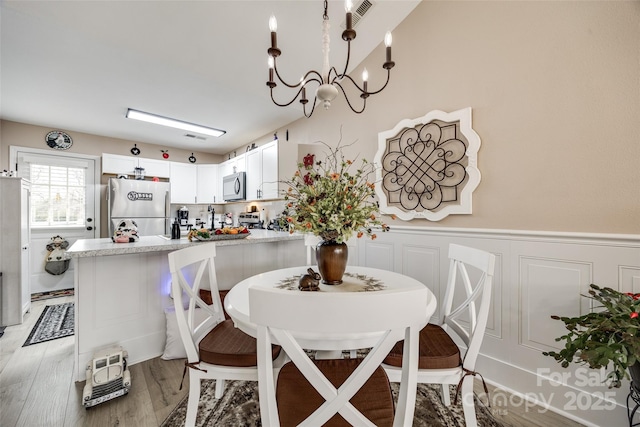 dining room with hardwood / wood-style flooring and a chandelier