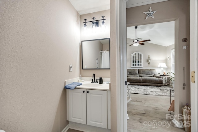 bathroom with hardwood / wood-style floors, ceiling fan, and vanity