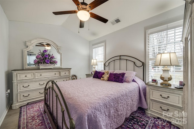 bedroom with hardwood / wood-style flooring, vaulted ceiling, and ceiling fan