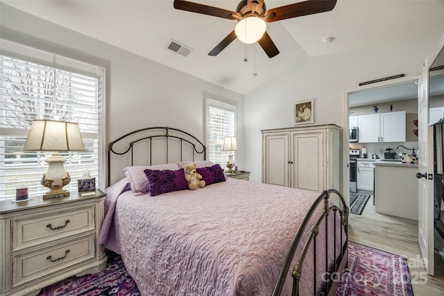 bedroom with light wood-type flooring, vaulted ceiling, and ceiling fan