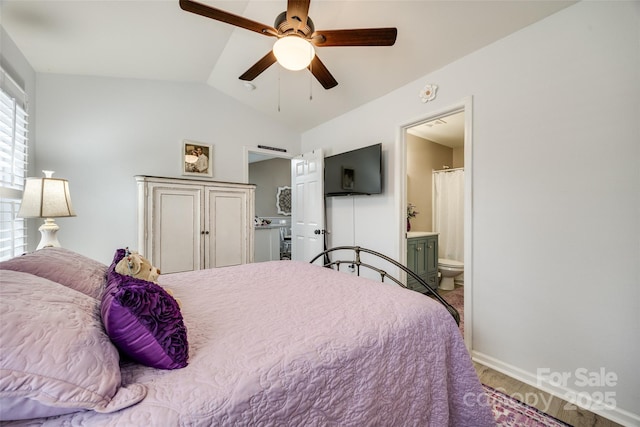 bedroom with ceiling fan, ensuite bath, and vaulted ceiling