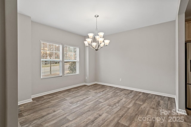 unfurnished room with light wood-type flooring and a notable chandelier