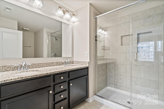 bathroom featuring a shower with door, tile patterned floors, and vanity