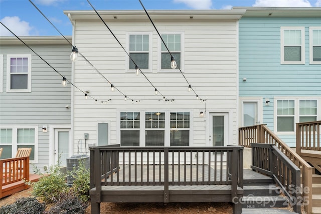 rear view of property featuring a deck and central AC