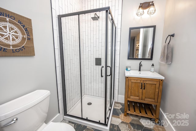 bathroom featuring toilet, vanity, and a shower with door