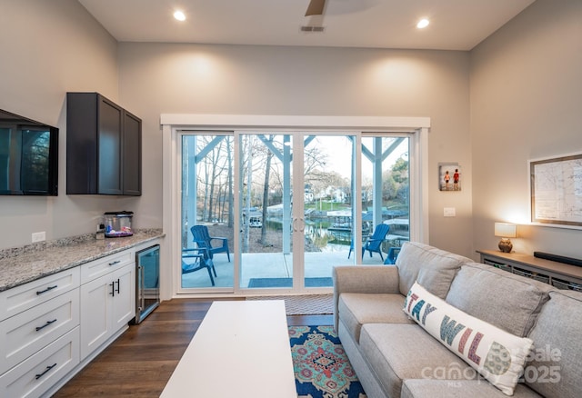 living room featuring wine cooler, ceiling fan, and dark wood-type flooring