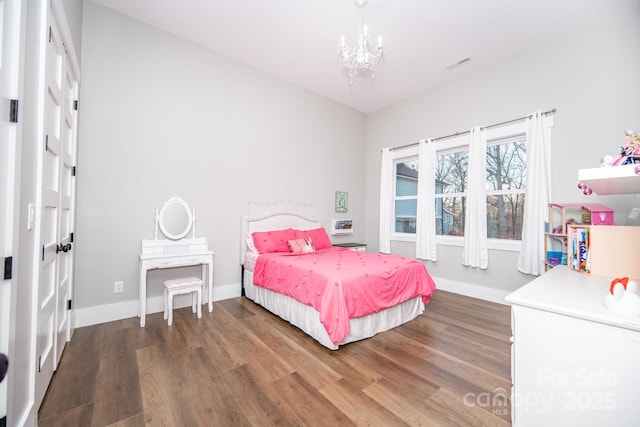 bedroom featuring dark wood-type flooring and a notable chandelier