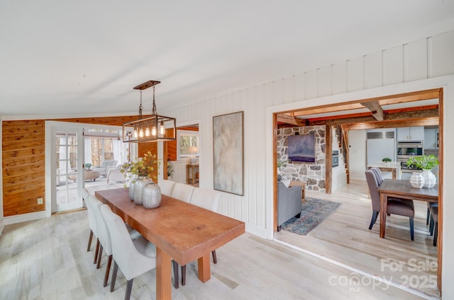 dining area with wooden walls and light hardwood / wood-style flooring