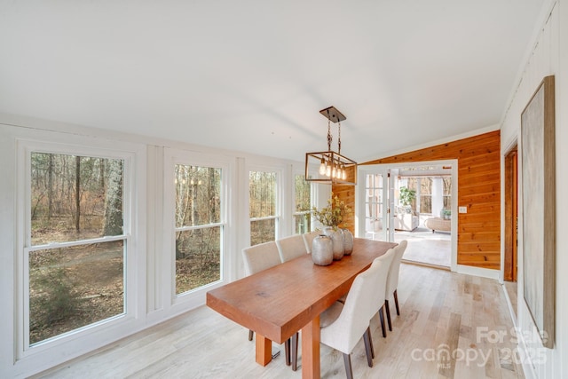 sunroom with lofted ceiling, a notable chandelier, and french doors