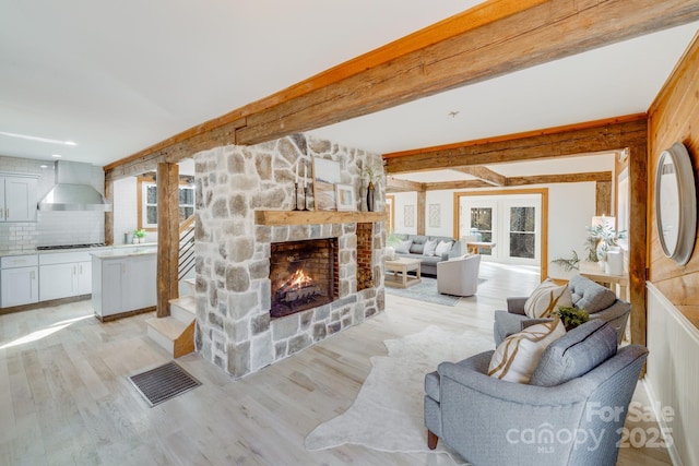 living room featuring a fireplace, light hardwood / wood-style floors, and a healthy amount of sunlight