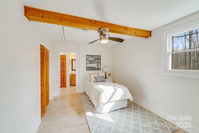 bedroom with ceiling fan, beam ceiling, light hardwood / wood-style floors, and a closet