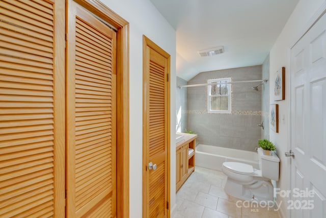 full bathroom with tiled shower / bath combo, vanity, tile patterned floors, and toilet